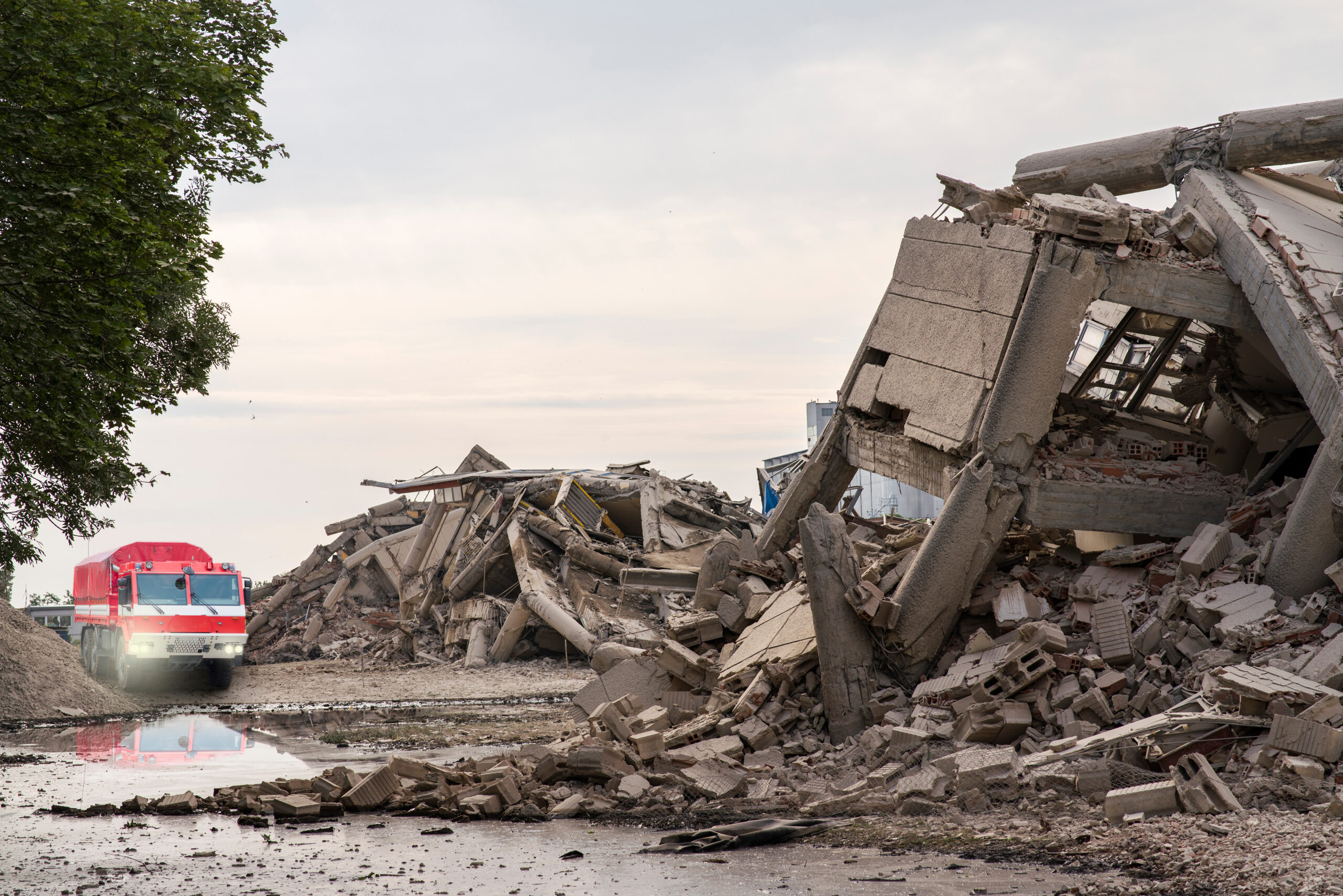 Rescue vehicle among collapsed buildings after an earthquake
