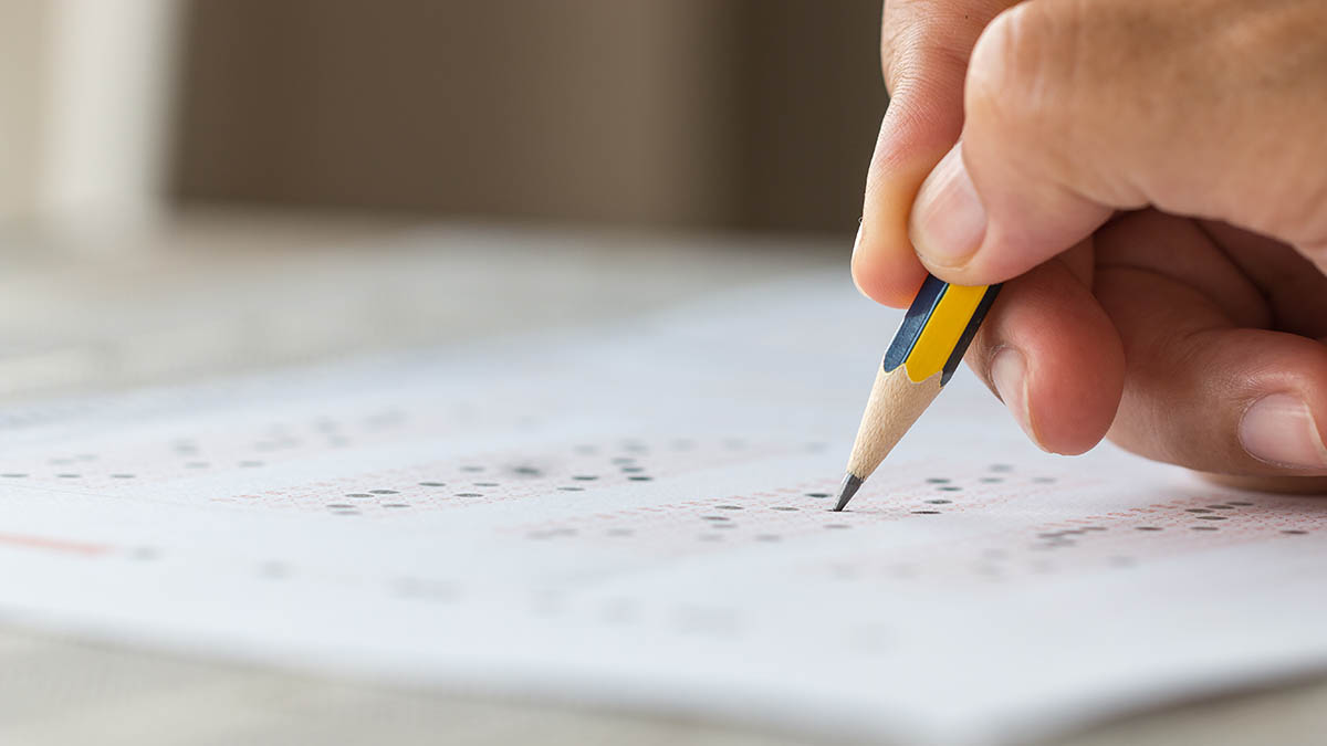 Close-up of a student filling an OMR answer sheet during a competitive exam