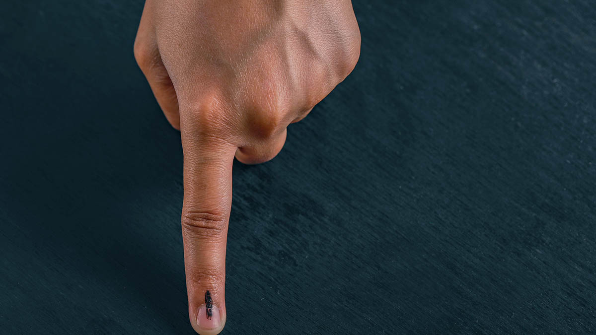 Indian voter showing inked finger after casting vote
