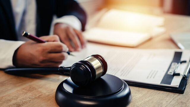 Legal documents and a wooden gavel on a desk